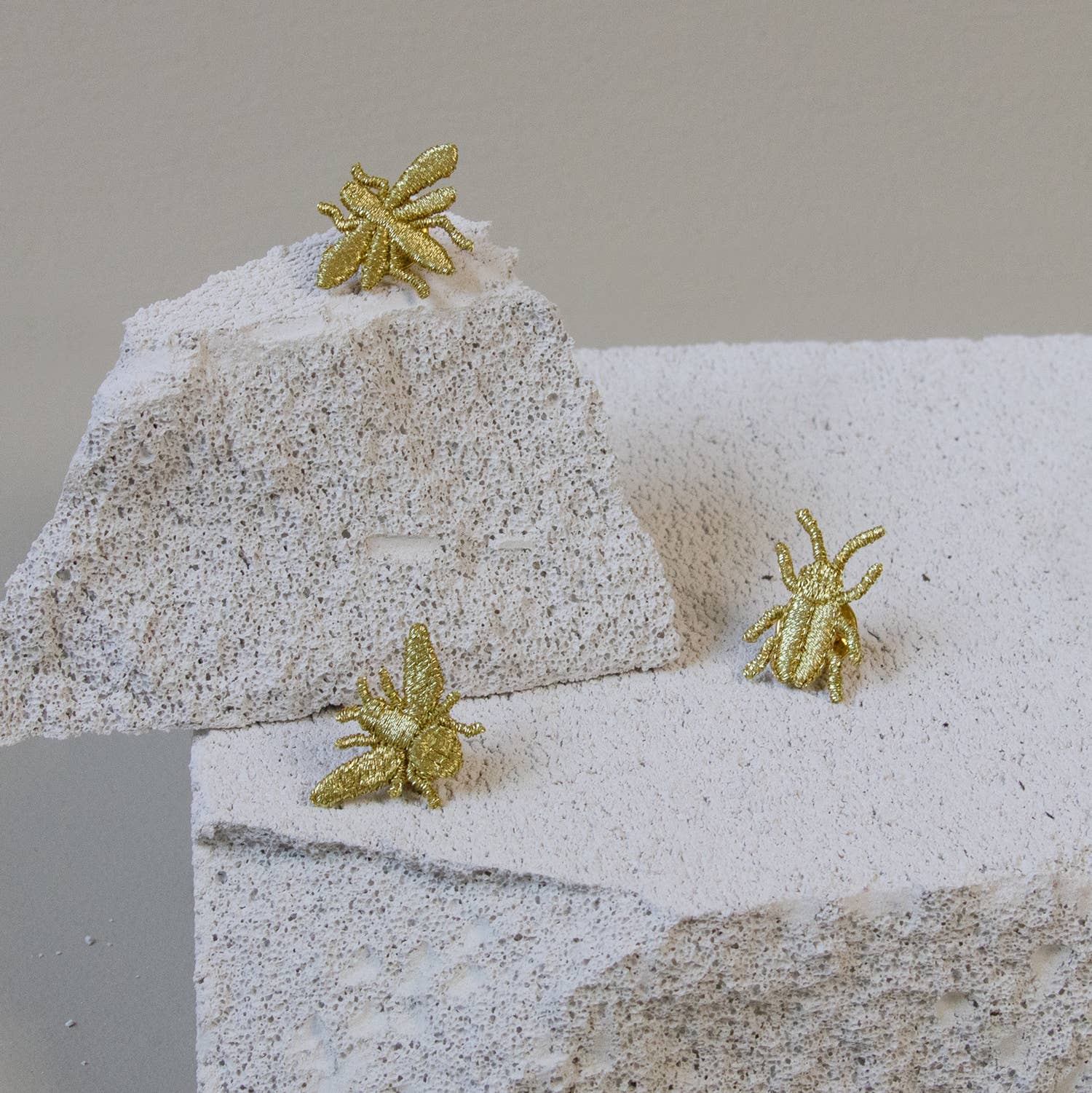 Golden embroidered bug pins featuring three tiny insect designs, perfect for plant lovers' decor or accessories.