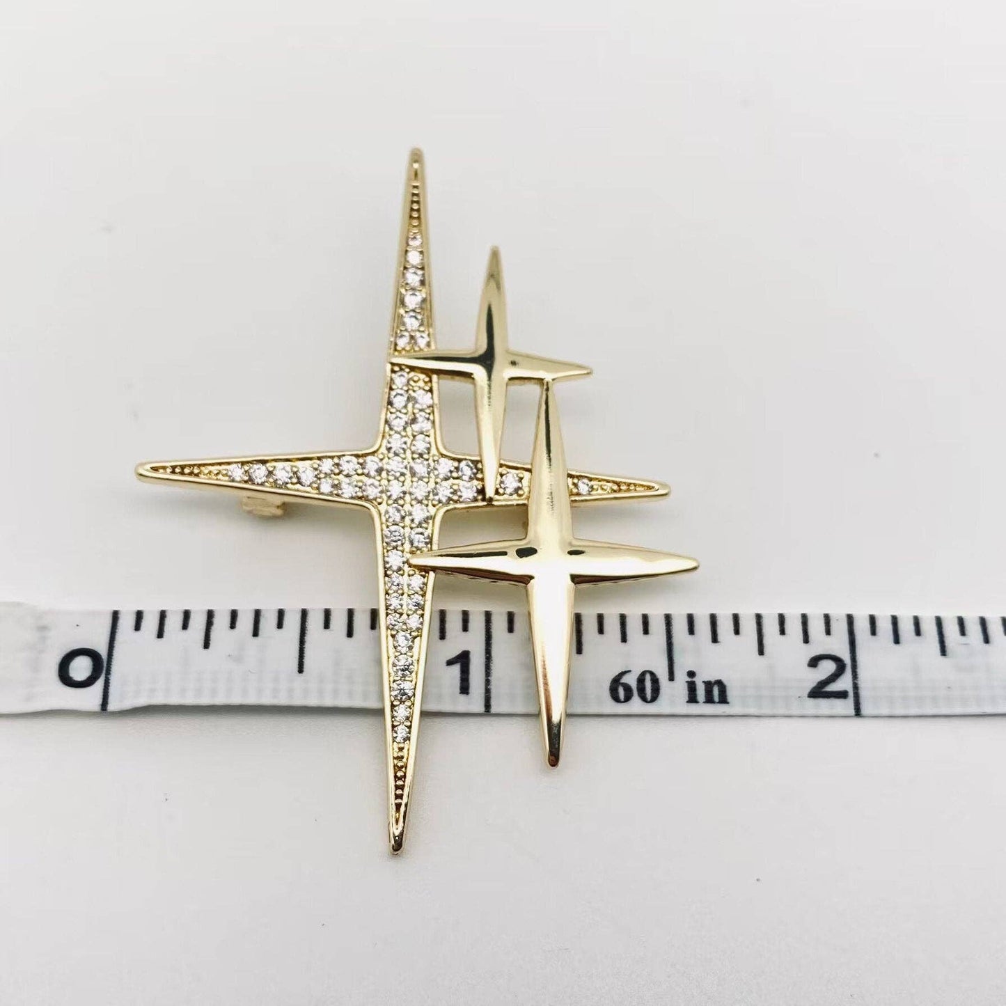 Mio Queena cubic zirconia star brooch pin with sparkling star design and silver-tone metal finish.