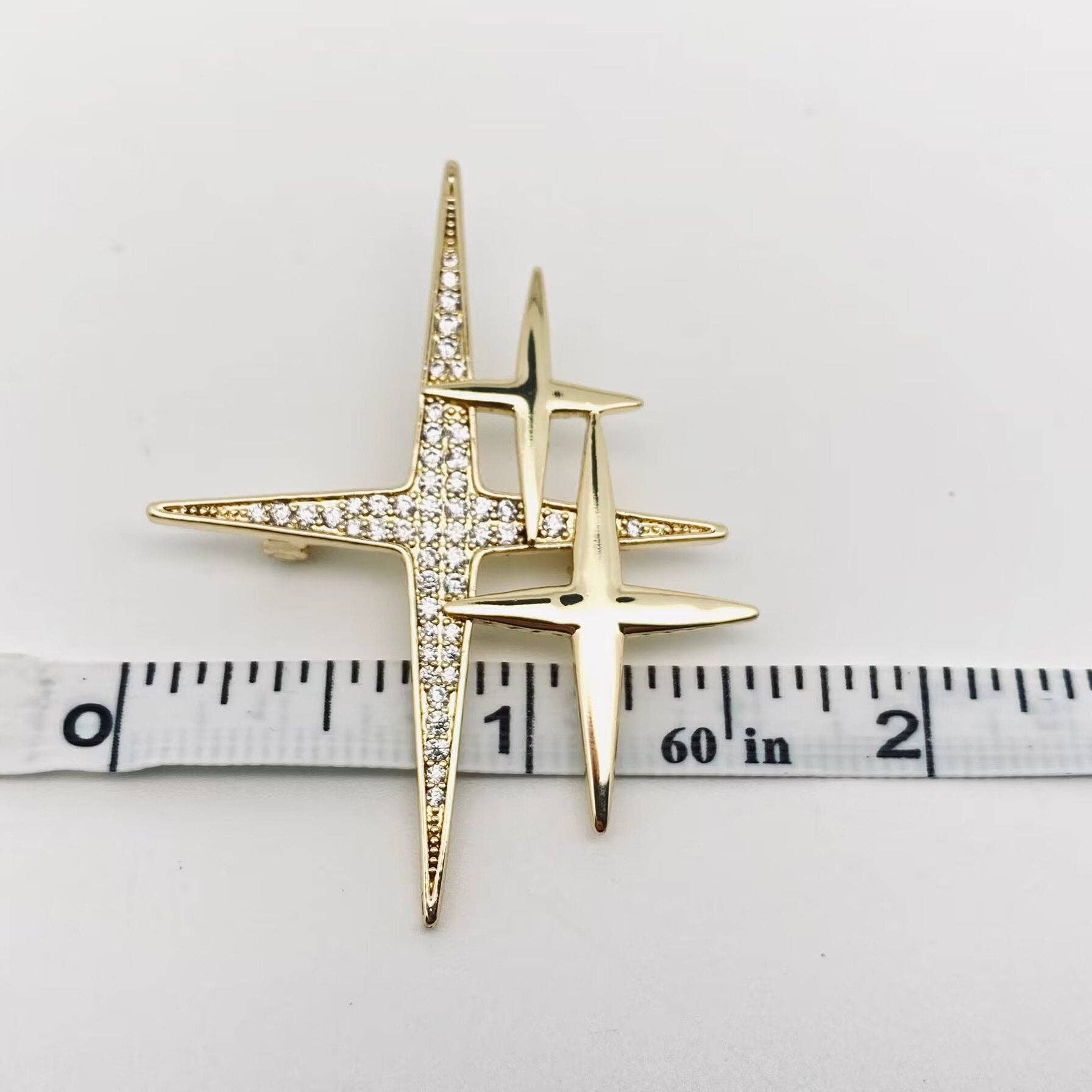 Mio Queena cubic zirconia star brooch pin with sparkling star design and silver-tone metal finish.