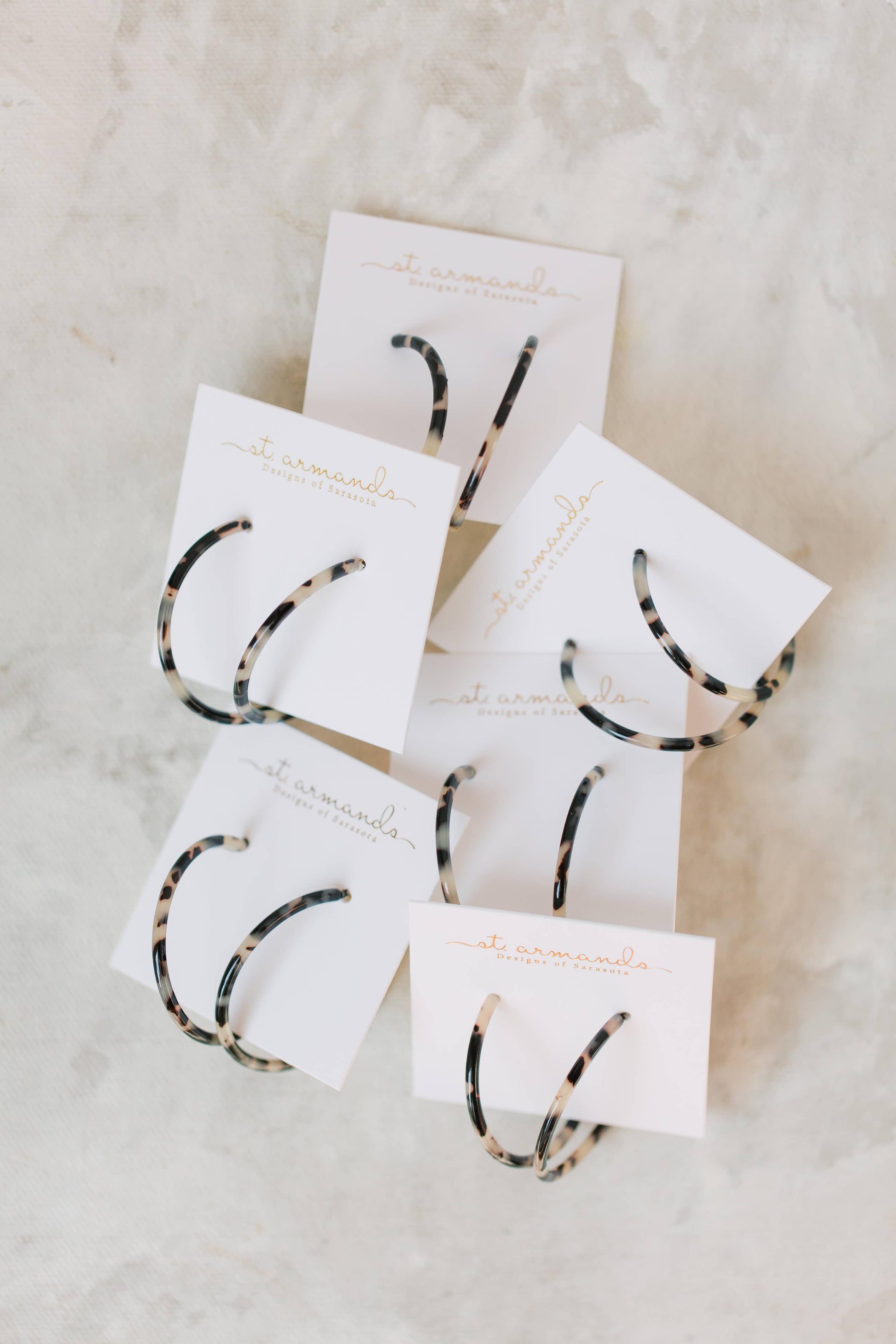 Skinny blonde tortoise hoop earrings by St Armands Designs of Sarasota, featuring lightweight, stylish gold-toned jewelry.