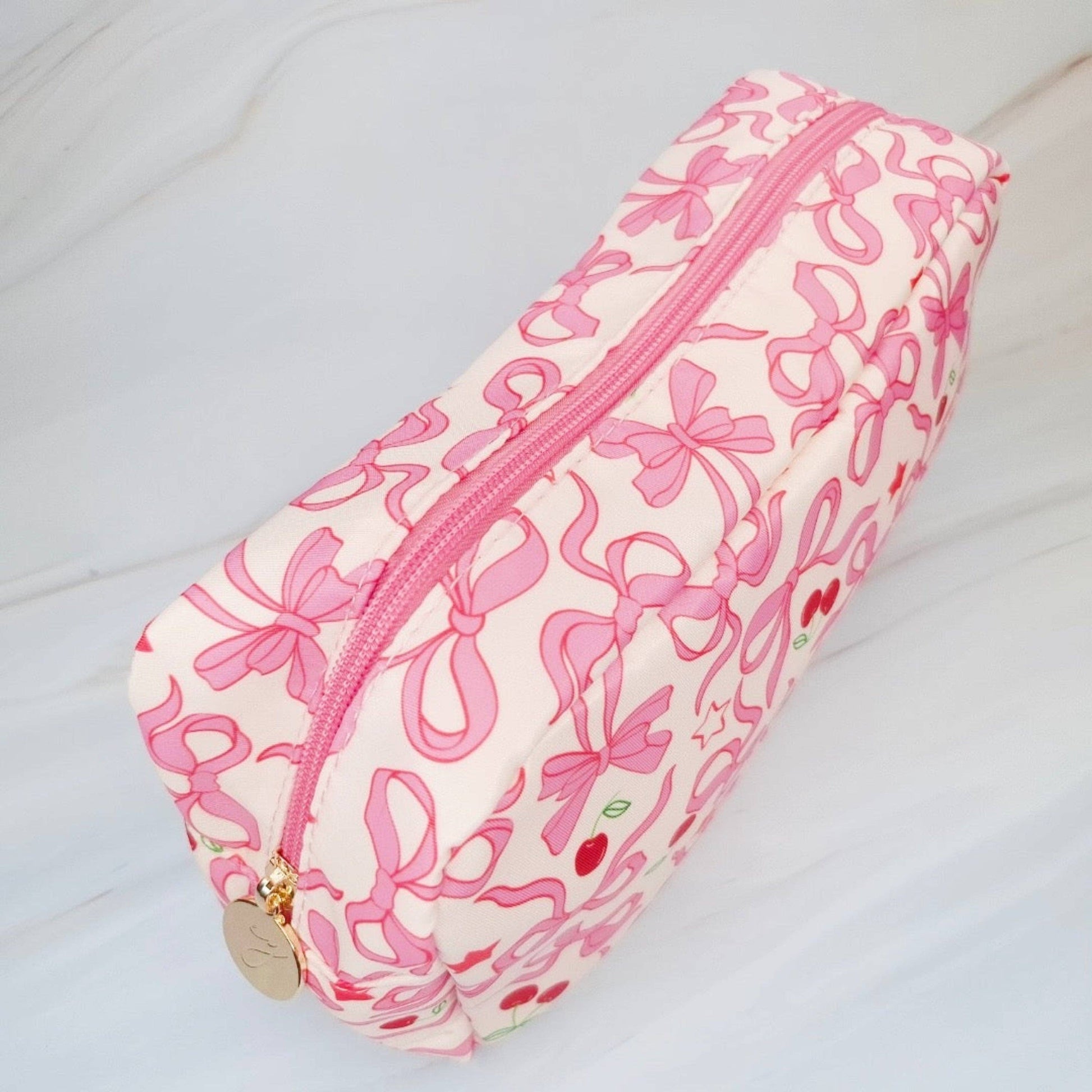 Ellison+Young Cherry Bowtiful everyday cosmetic bag with cherry print, compact design, and zipper closure for makeup and accessories.