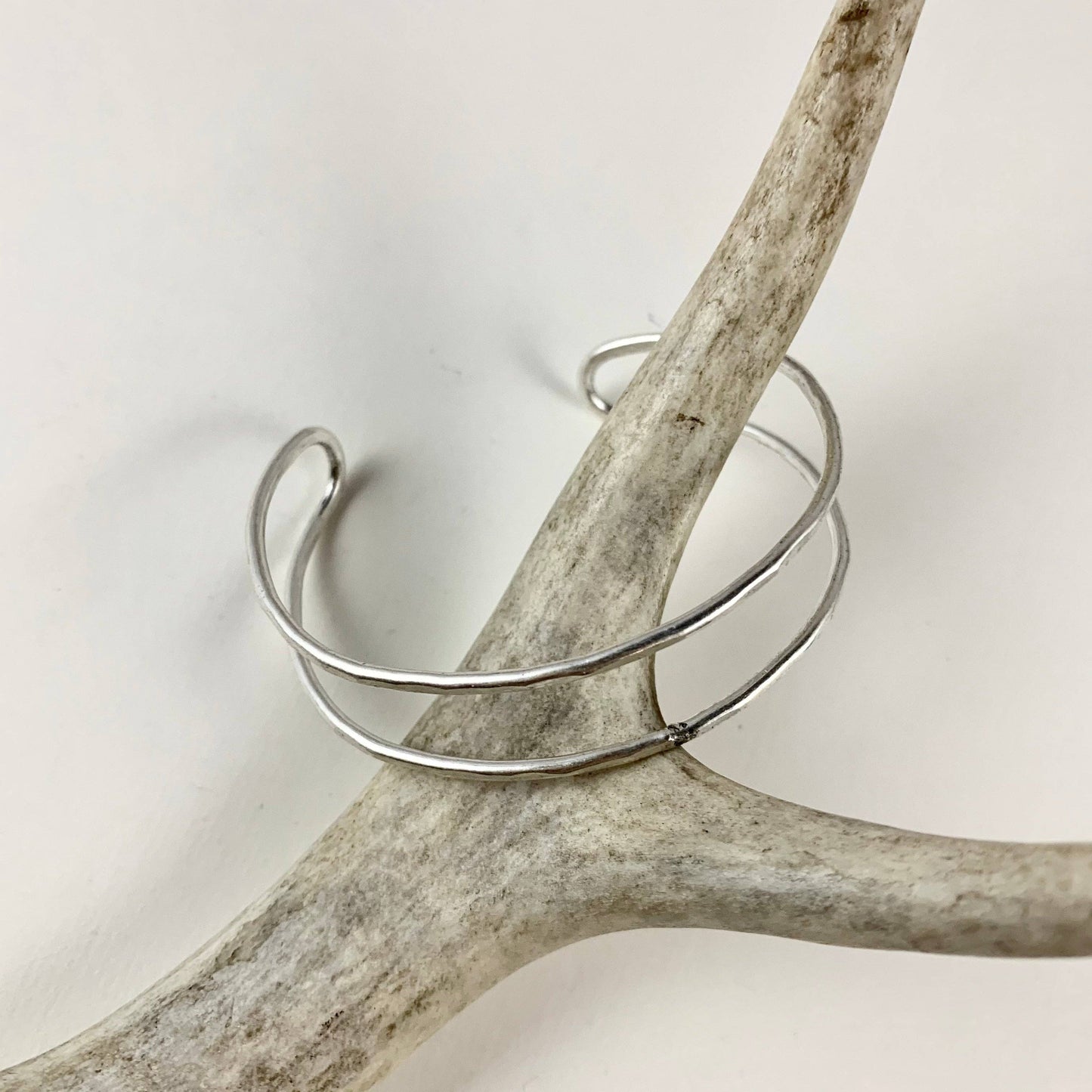 Handmade She-ra cuff bracelets by Fluff Hardware, featuring detailed metalwork and intricate design on the wrist accessories.