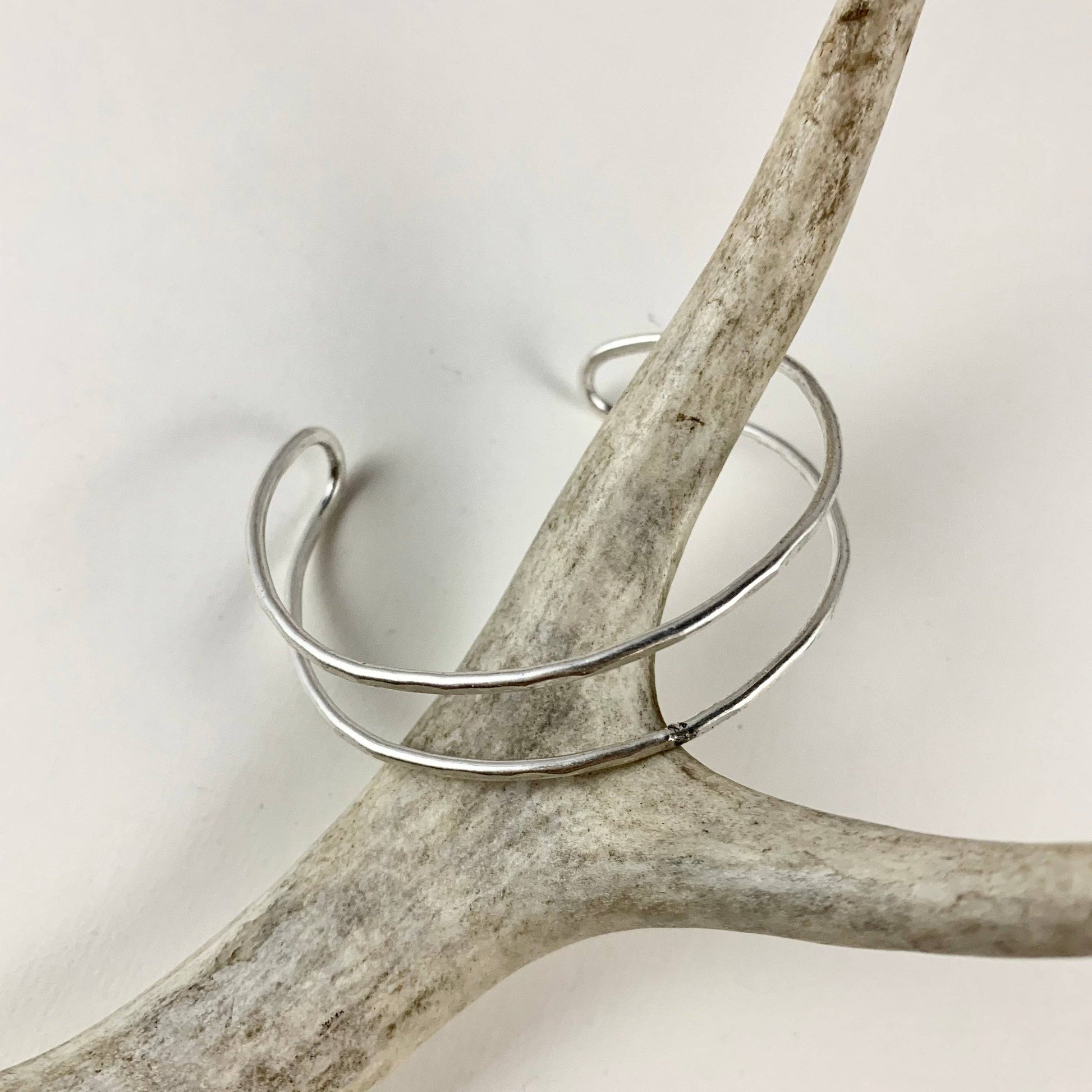 Handmade She-ra cuff bracelets by Fluff Hardware, featuring detailed metalwork and intricate design on the wrist accessories.