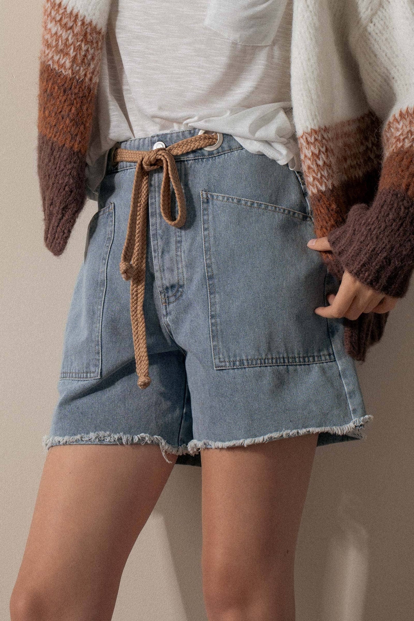 Urban Daizy high-waisted denim shorts with frayed hem, showcasing a casual summer style and distressed denim fabric.