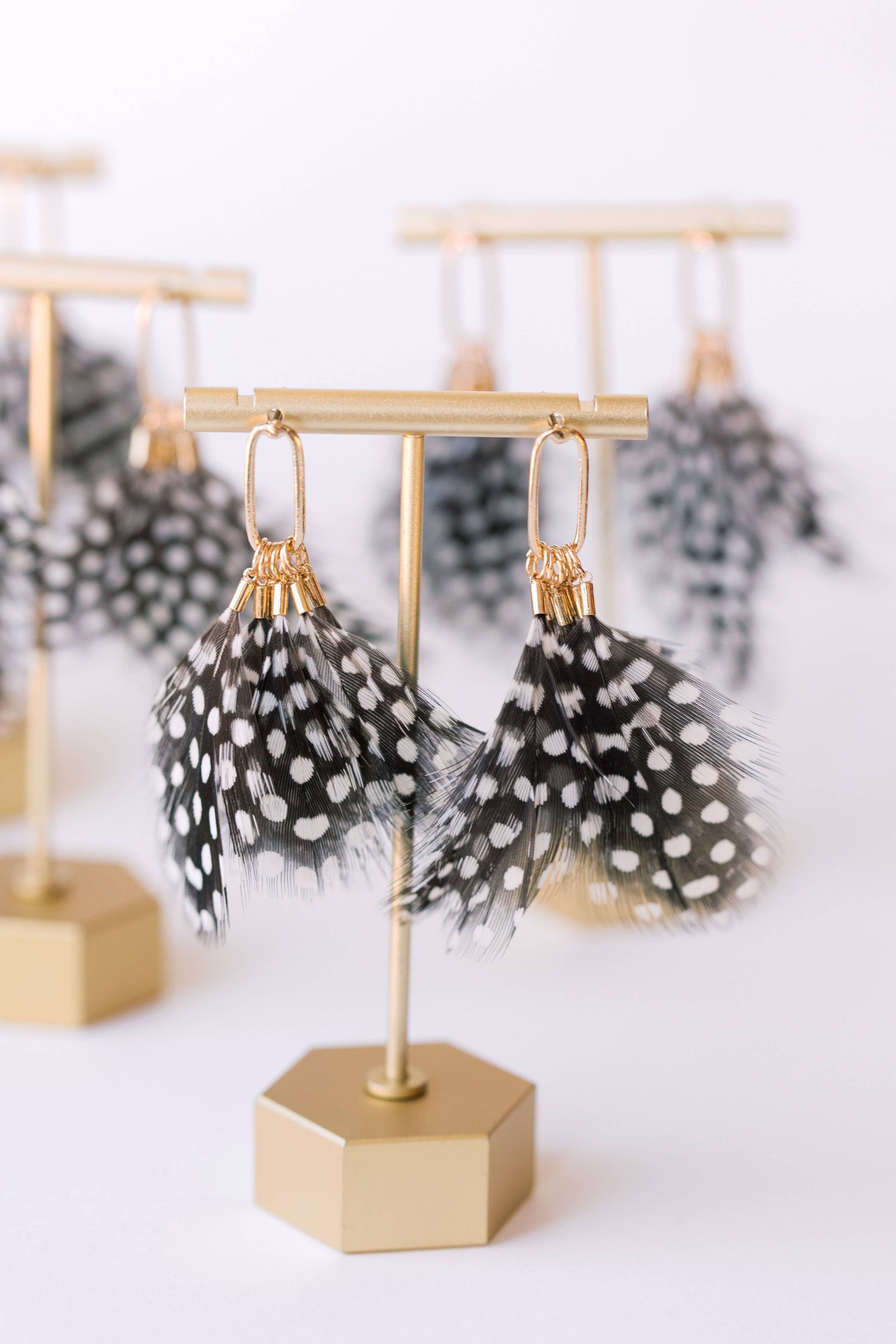 Spotted feather earrings by St Armands Designs of Sarasota, featuring lightweight feather dangles with black and white spots.