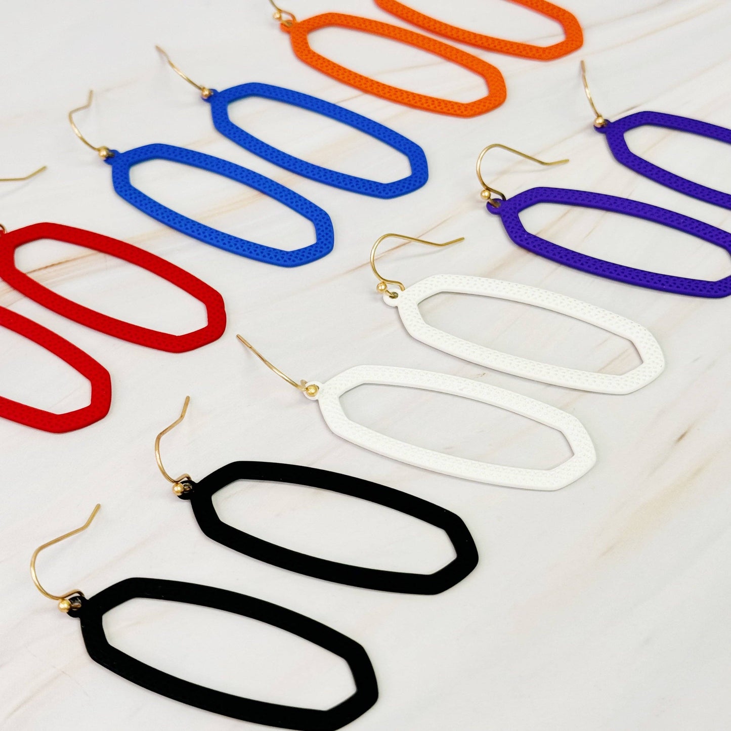 Ellison+Young Shape Of Game earrings featuring modern geometric design in silver, displayed on a neutral background.