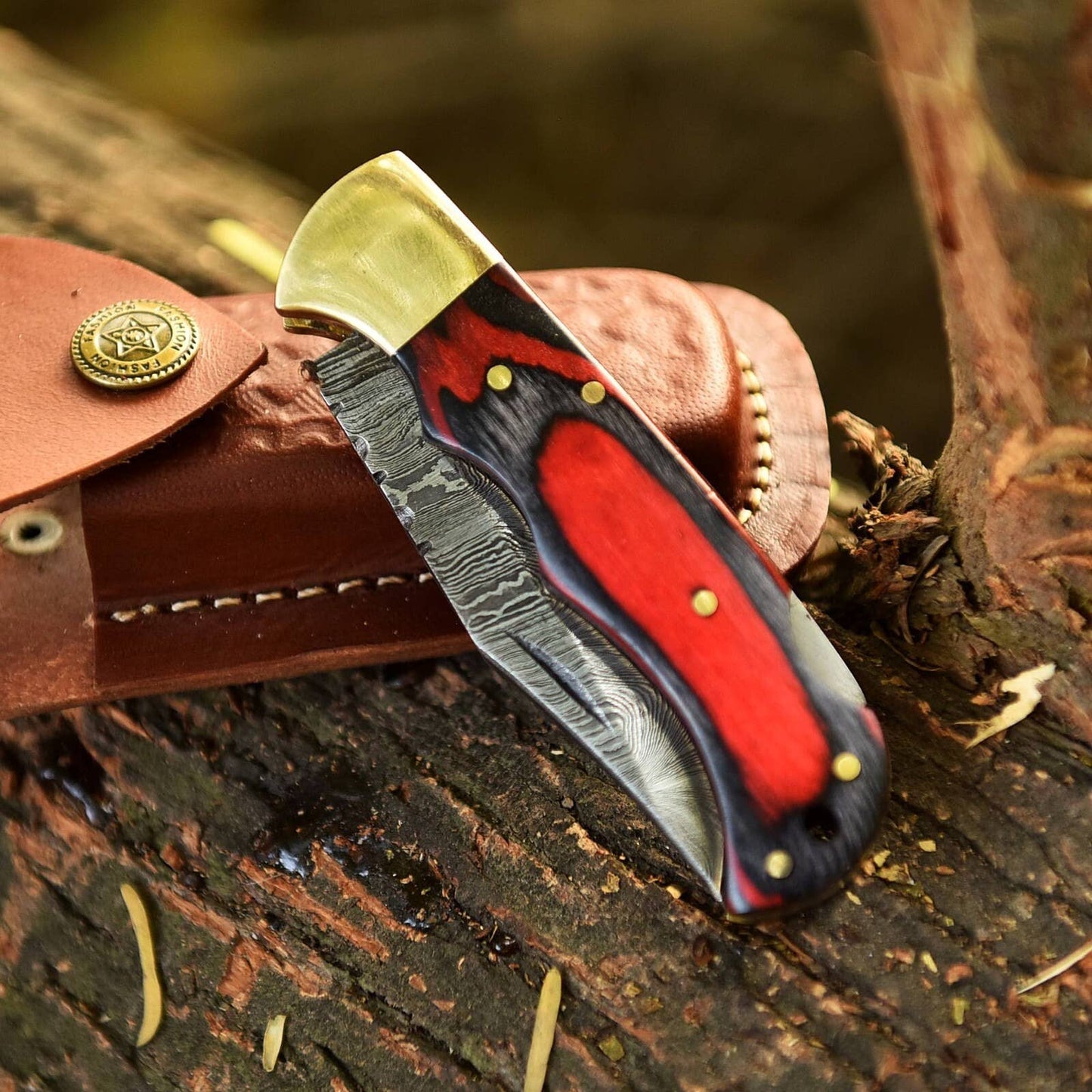 Handmade Damascus red and black wood folding knife by Liconte LLC with a polished blade and wooden handle.
