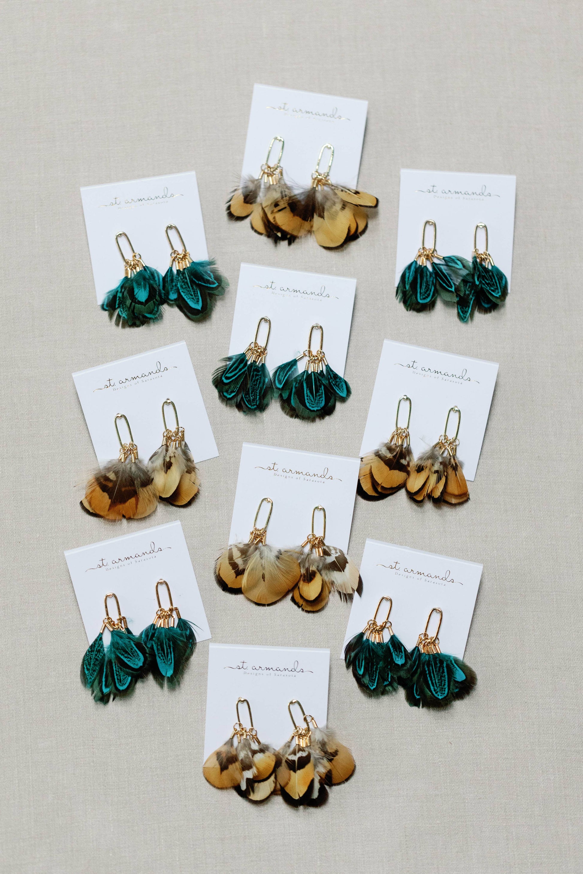 Peacock feather statement tassel earrings with colorful feathers and gold accents, designed by St Armands Designs of Sarasota.