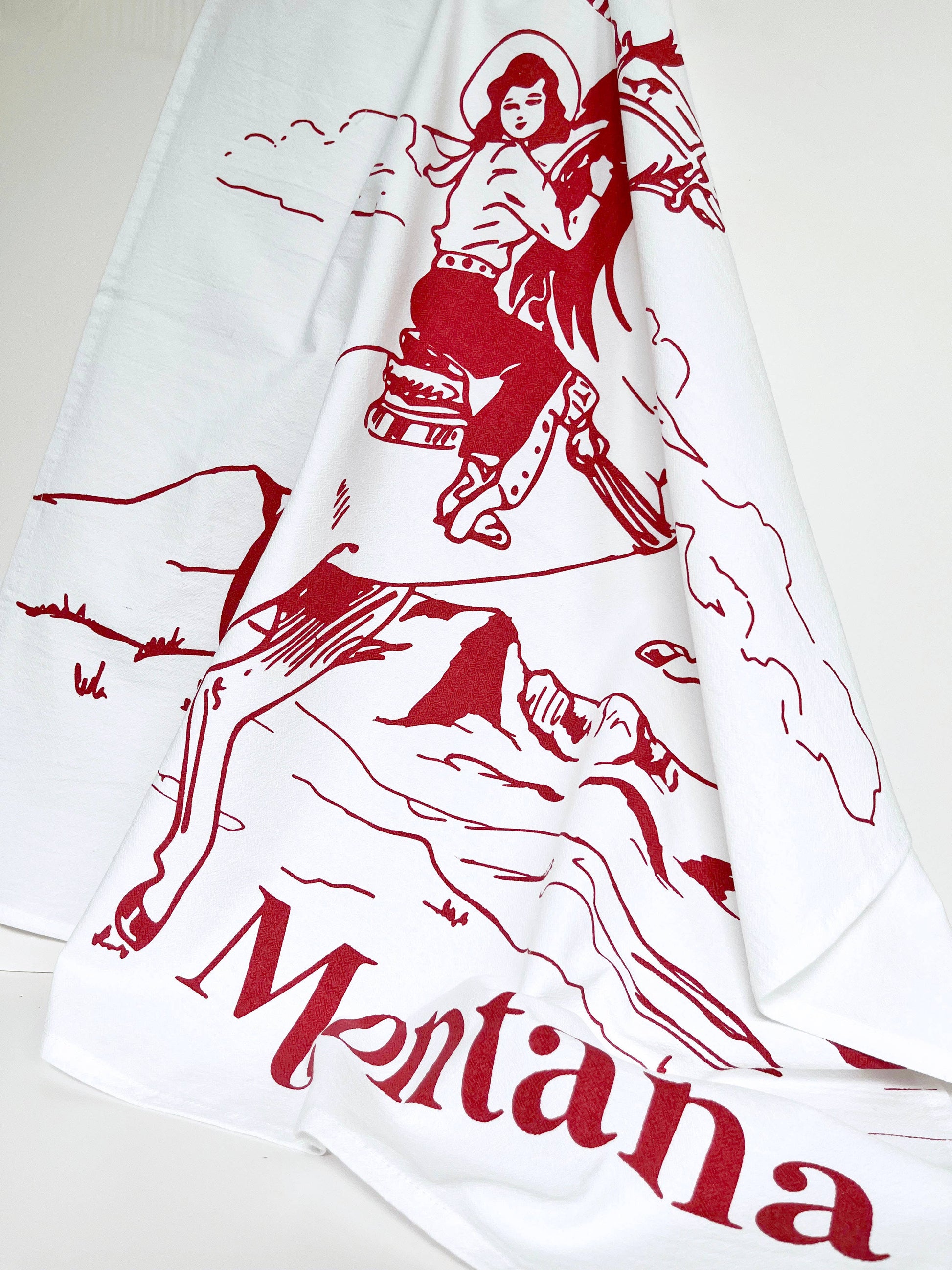 No Place Like Montana cowgirl kitchen towel from The Coin Laundry featuring a colorful Montana-themed design for kitchen decor.