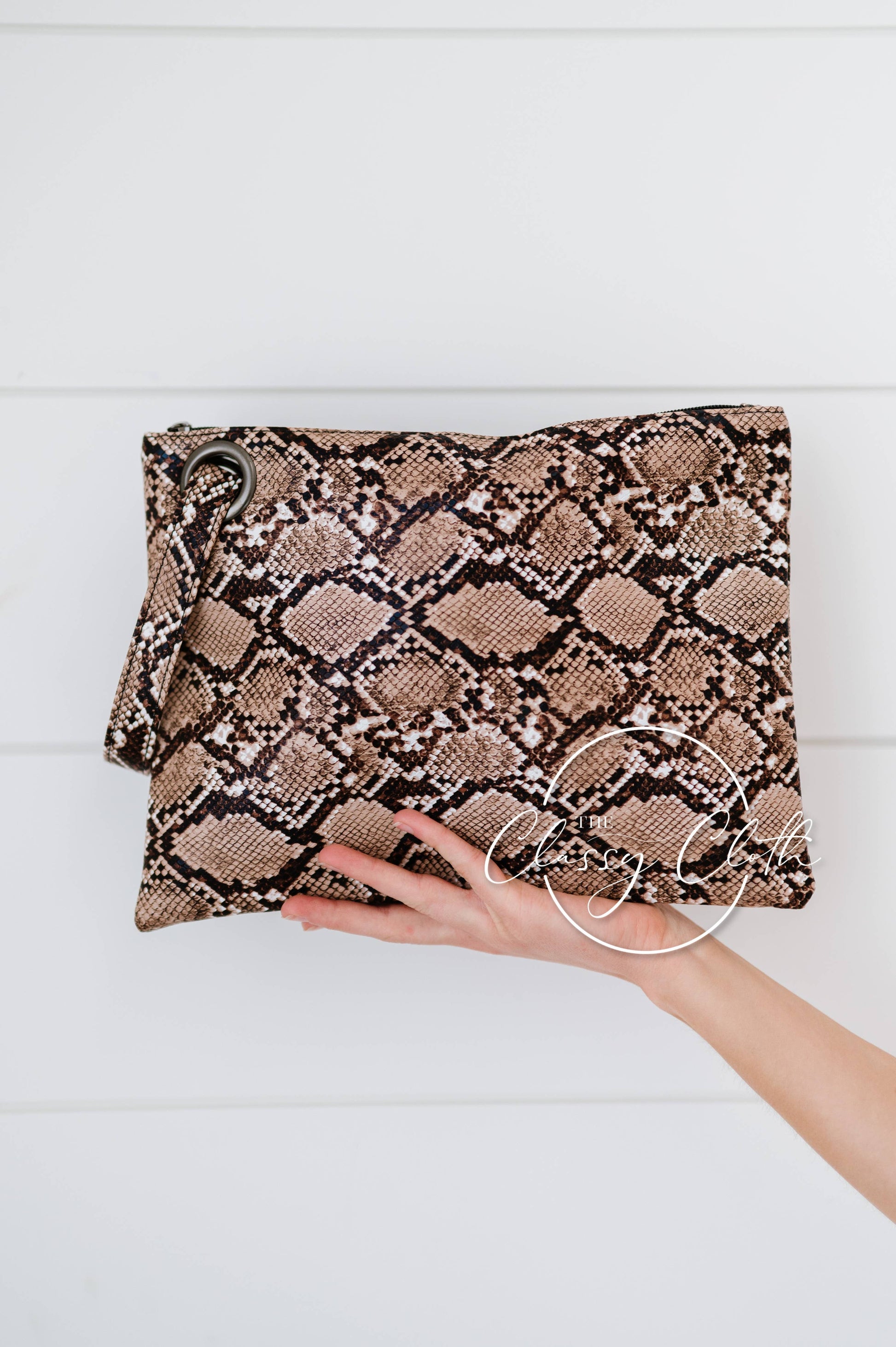 Brown snakeskin trendy clutch bag by The Classy Cloth WS, featuring a sleek design and compact size for stylish occasions.