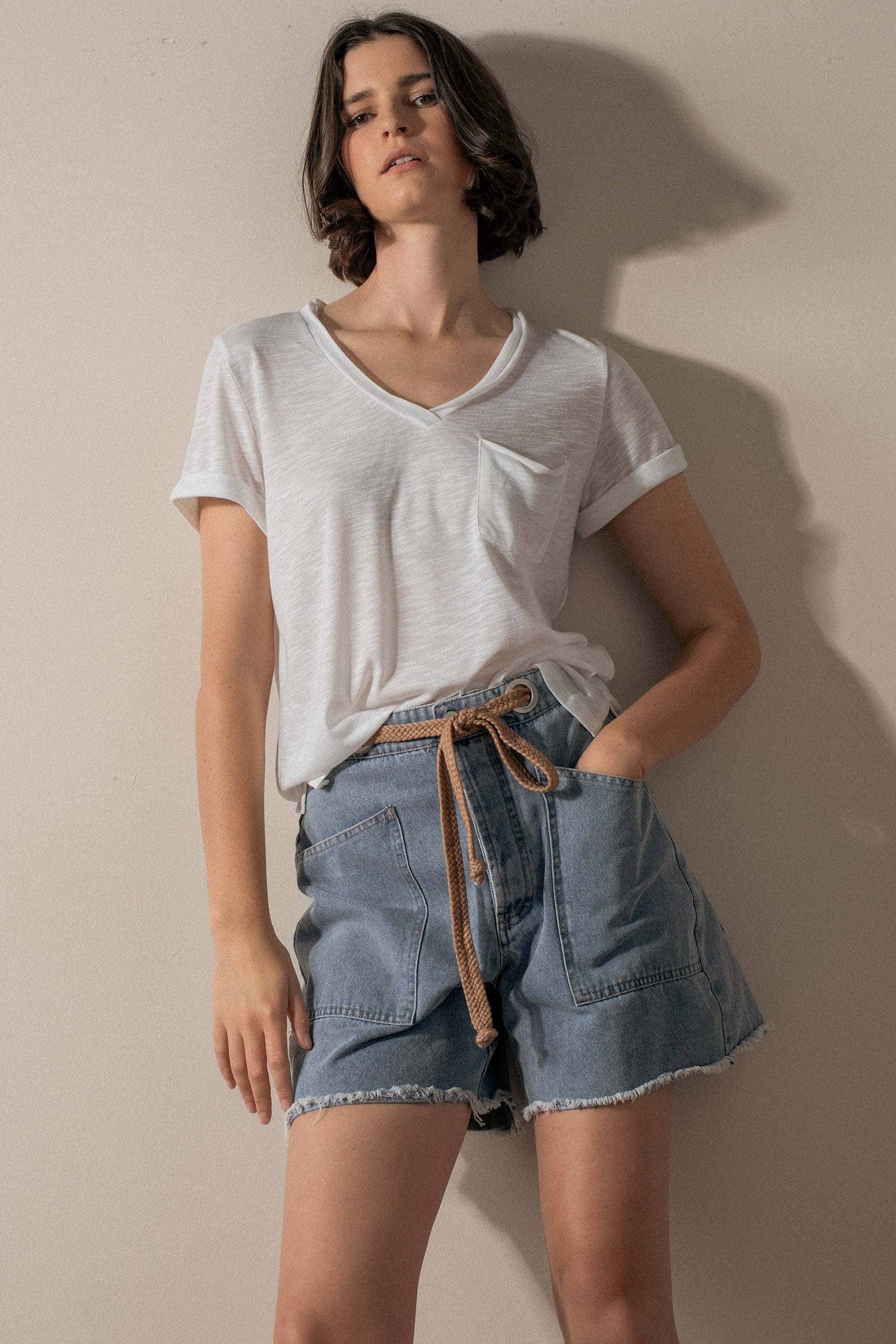 Urban Daizy high-waisted frayed hem denim shorts laid flat, showing distressed edges and classic blue denim fabric.