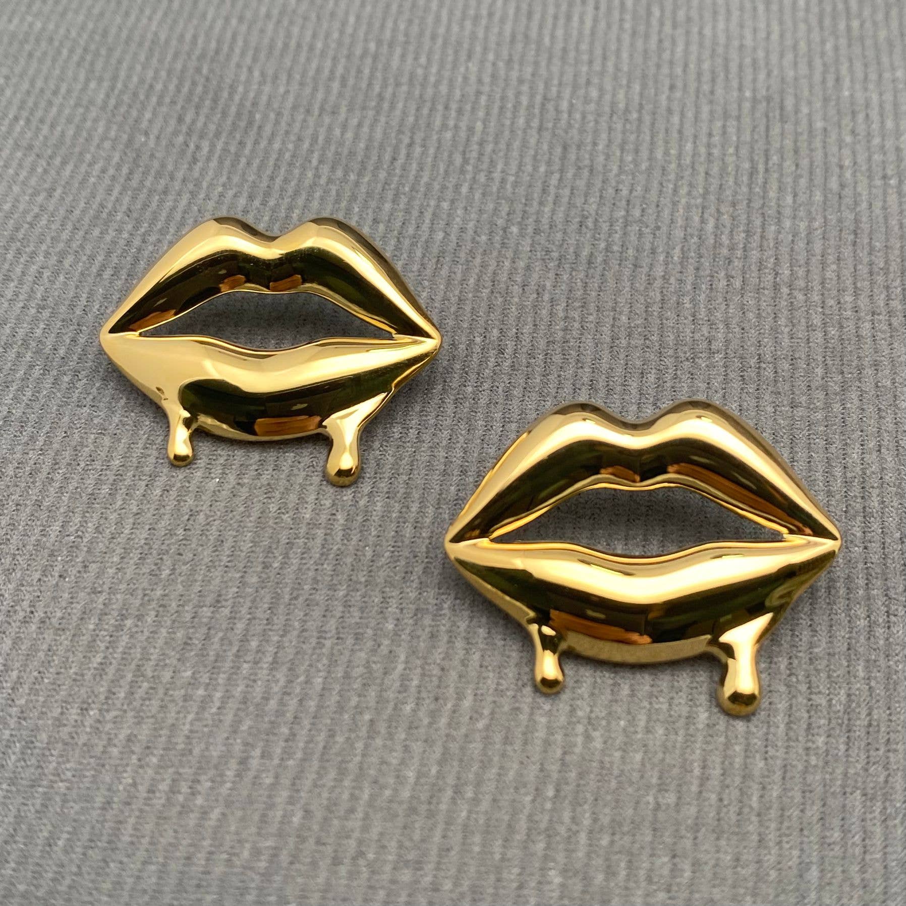 Glossy Lips earrings by Mio Queena featuring shiny, lip-shaped silver earrings with a smooth, reflective finish.