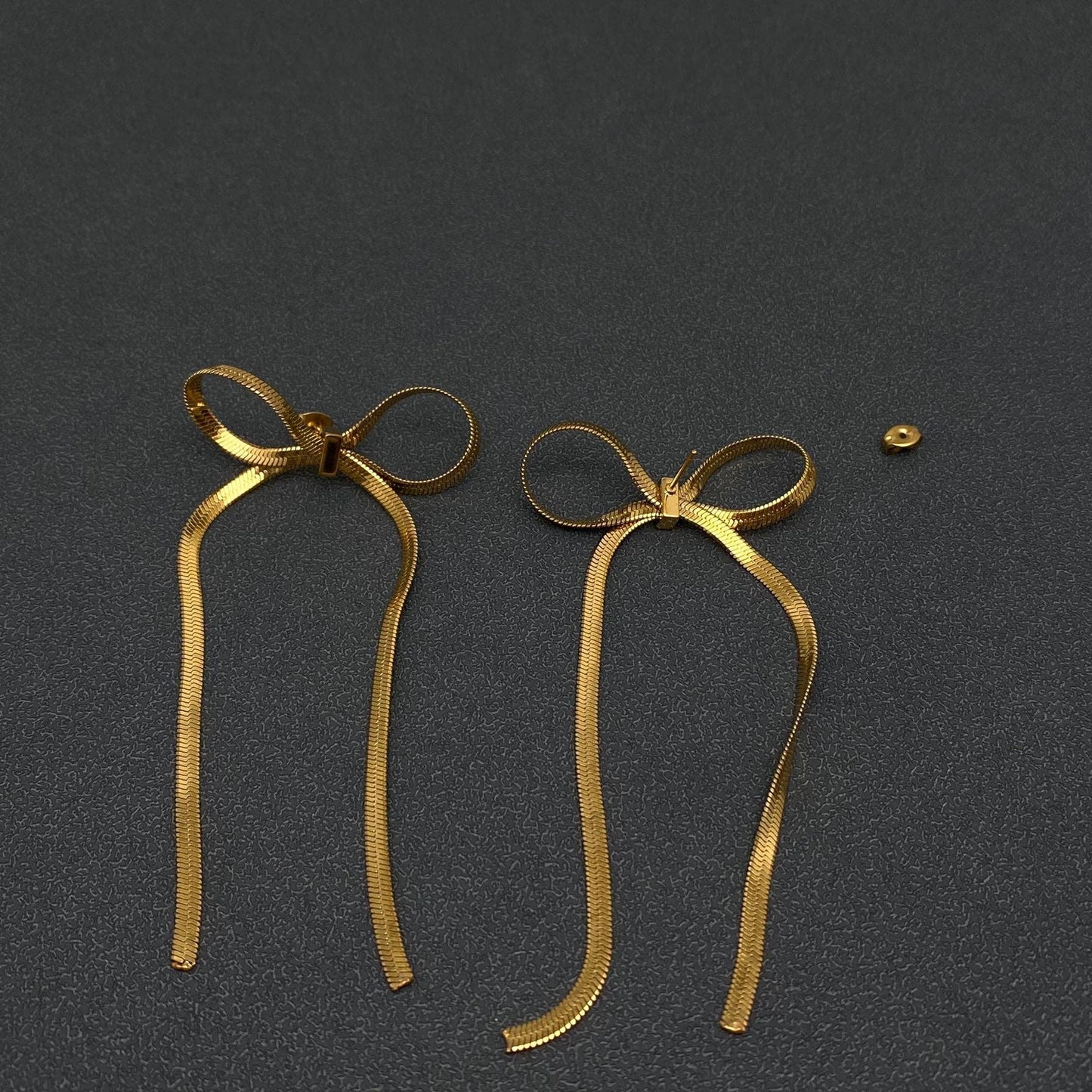 Mio Queena chain bow earrings with delicate dangling chains and bow design, stylish jewelry for women.