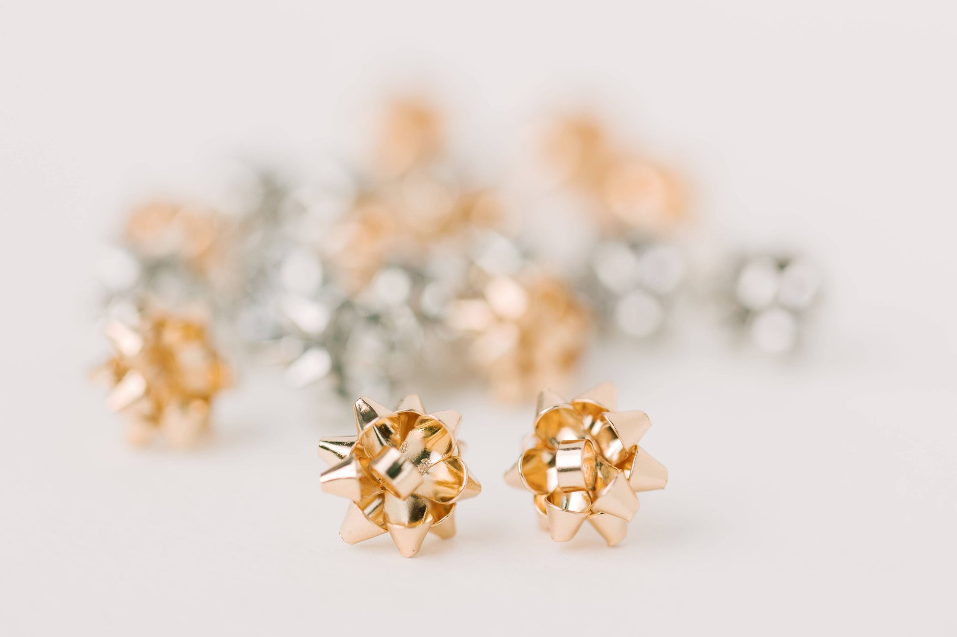 Gold Present Bow Earrings by St Armands Designs of Sarasota featuring elegant bow-shaped jewelry with a shiny gold finish.
