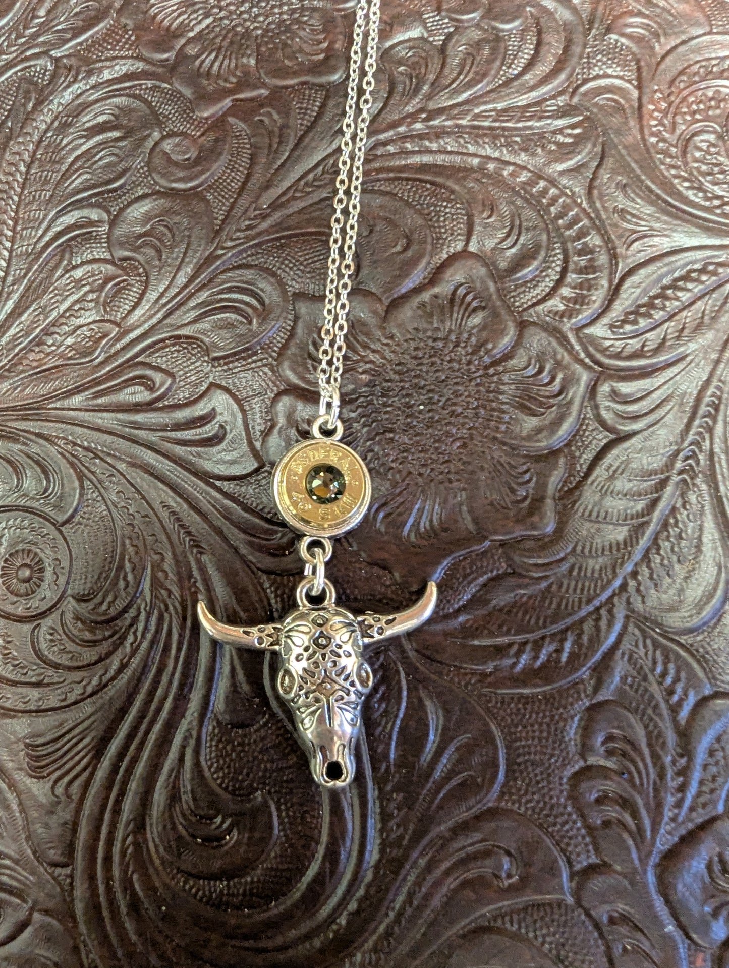 Silver cow skull necklace with caliber bezel pendant, crafted by BadAssBabe, featuring a detailed skull design on a chain.