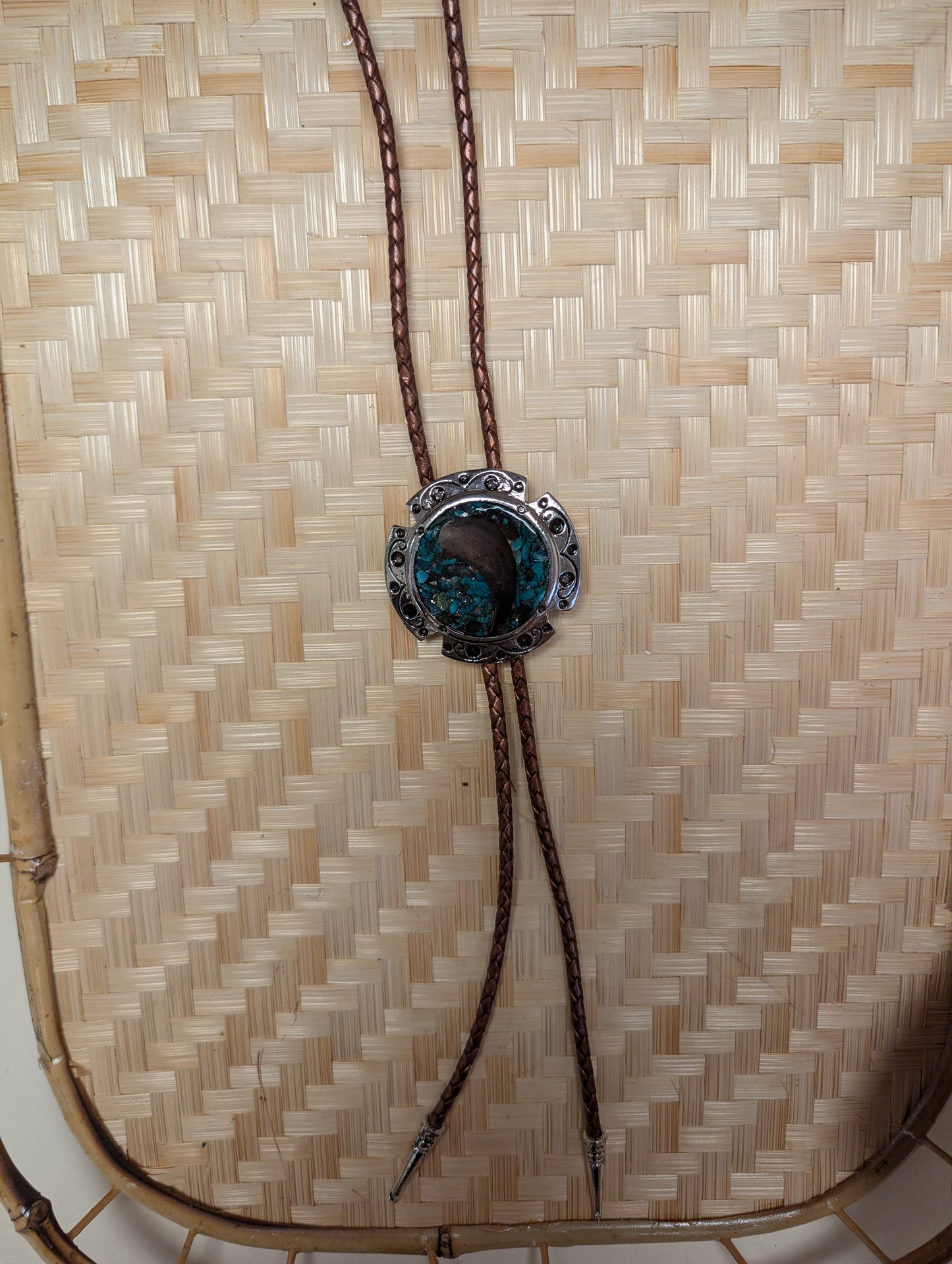 Silver BadAssBabe bolo tie featuring a detailed western-style metal clasp and black cord for a bold, stylish look.