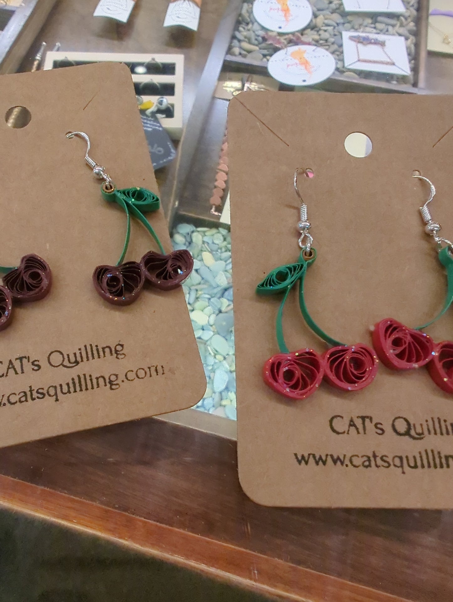 Cat's Quilling earrings featuring delicate quilled cat designs on gold-tone hooks, showcasing intricate craftsmanship.