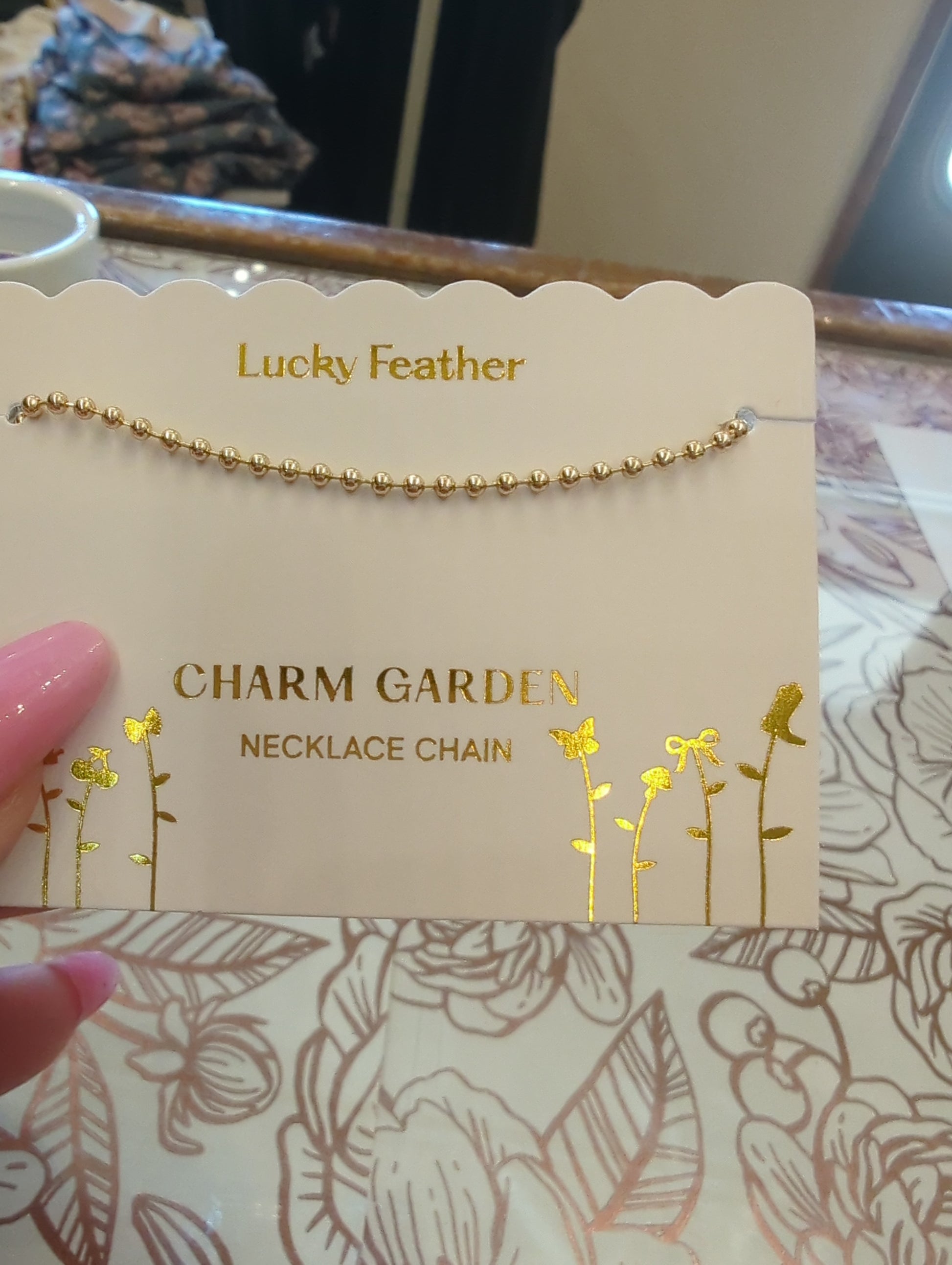 Gold necklace chain from Lucky Feather featuring a delicate charm, perfect for everyday wear and adding a subtle touch of elegance.