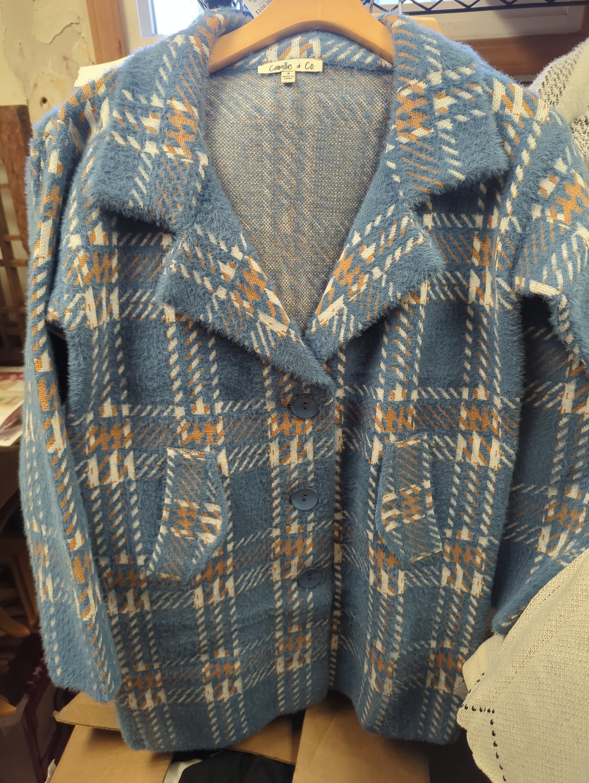 Camille & Co. soft car coat jacket in neutral fabric, displayed on a hanger with a folded collar and long sleeves.