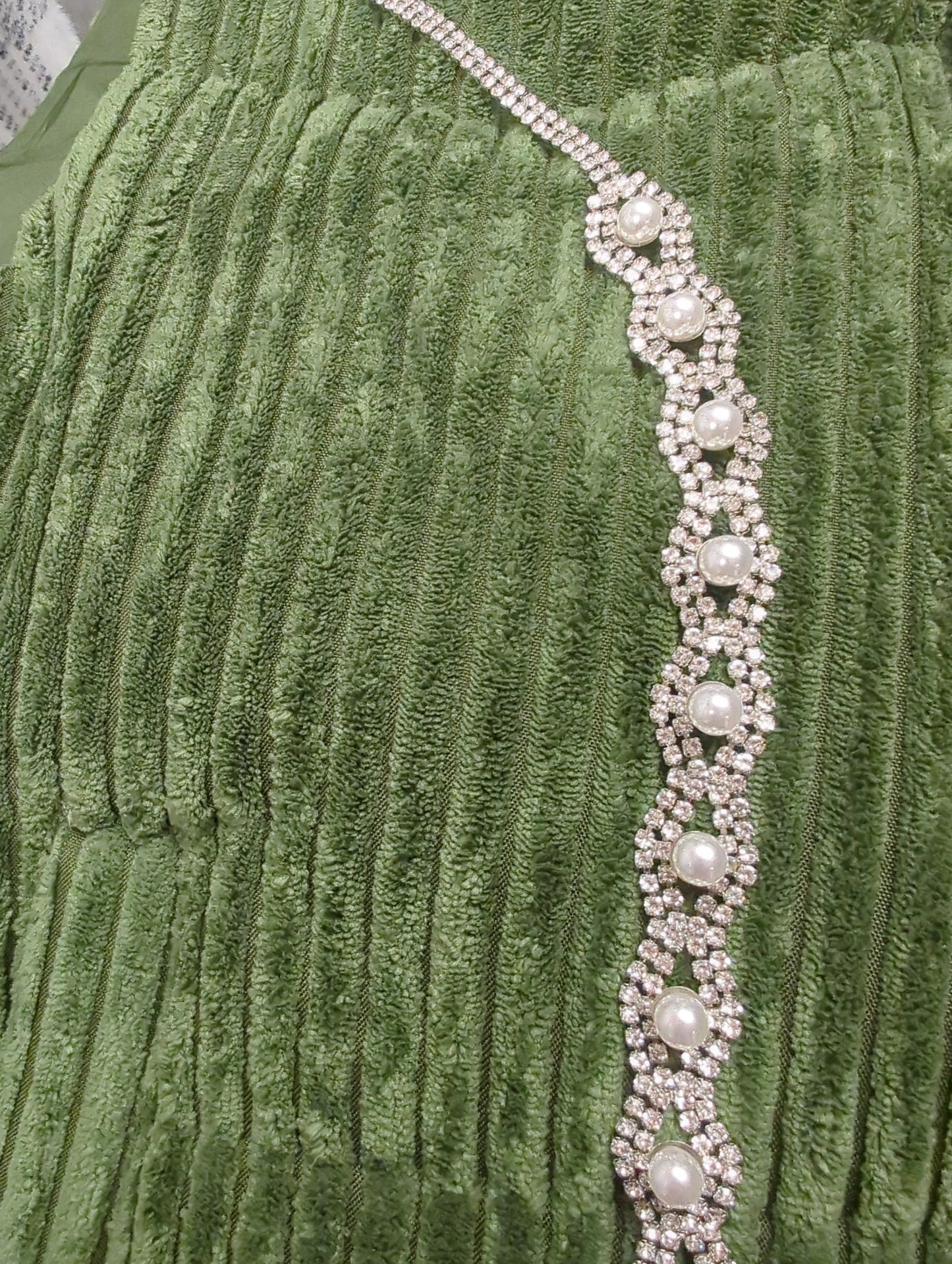 Joia rhinestone and pearl belt featuring sparkling rhinestones and elegant pearls on a sleek fabric strap.