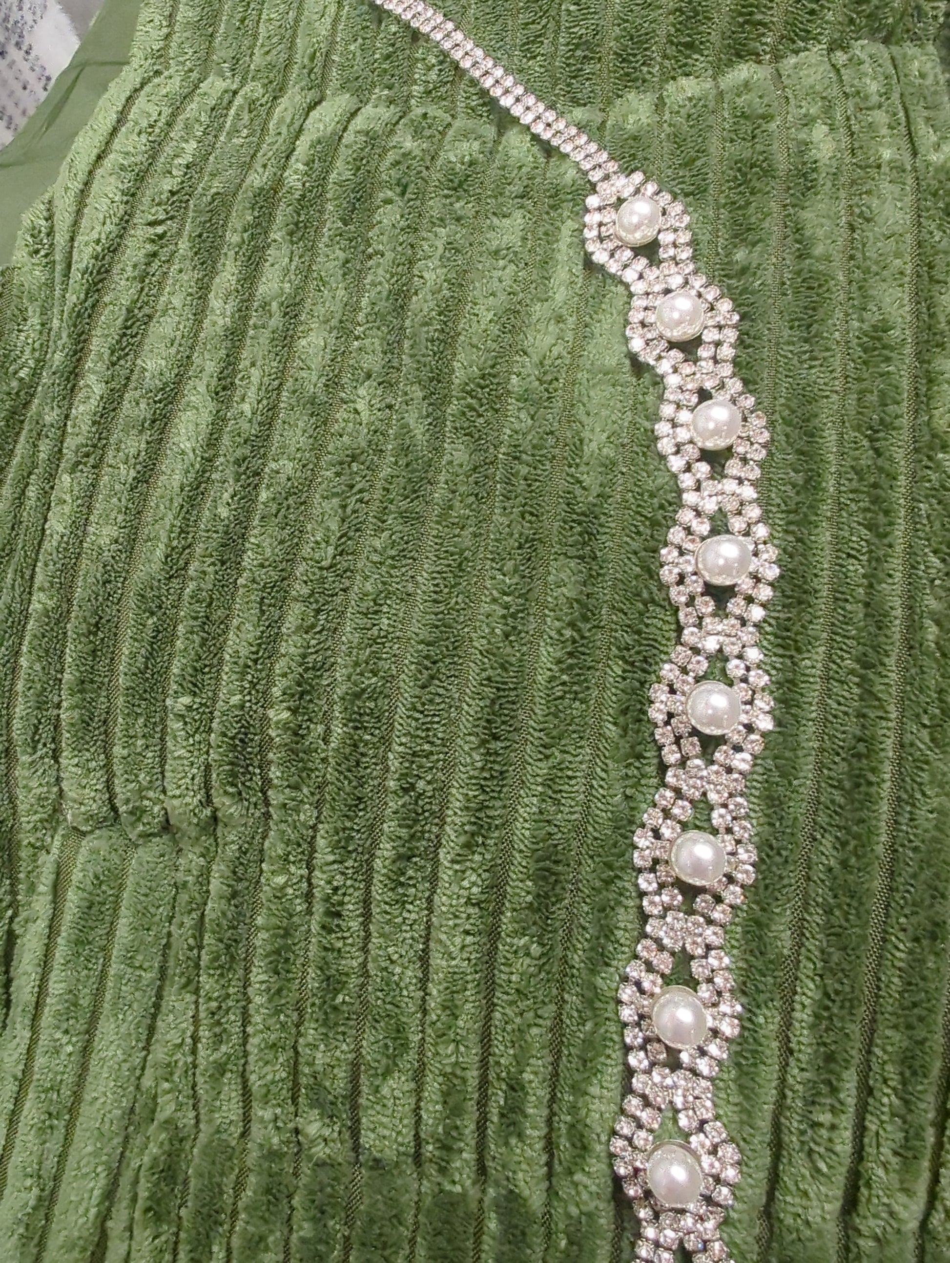 Joia rhinestone and pearl belt featuring sparkling rhinestones and elegant pearls on a sleek fabric strap.