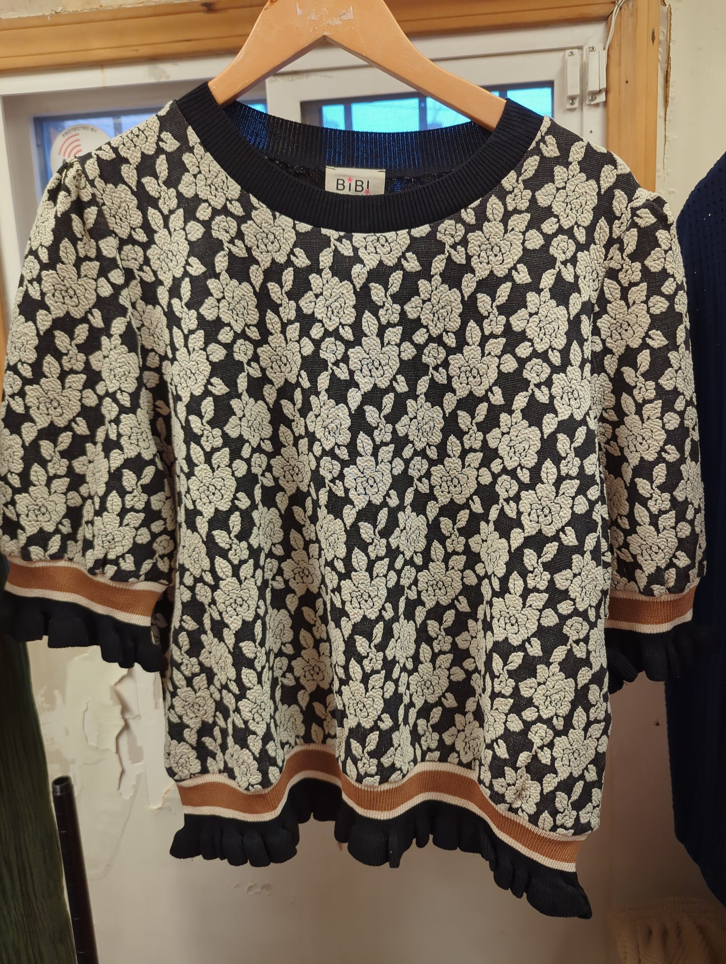 BiBi A Rose is a Rose sweater featuring a floral rose design, soft knit fabric, and classic fit in a cozy sweater style.
